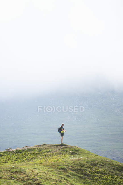 Mature man standing on mountain — Photo de stock