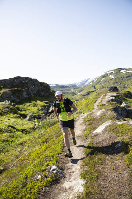 Uomo maturo che fa jogging in montagna — Foto stock