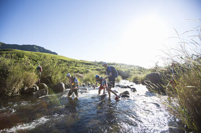Men and women hiking over river — Stock Photo