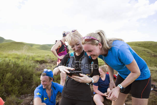 Amici che guardano smart phone durante le escursioni — Foto stock