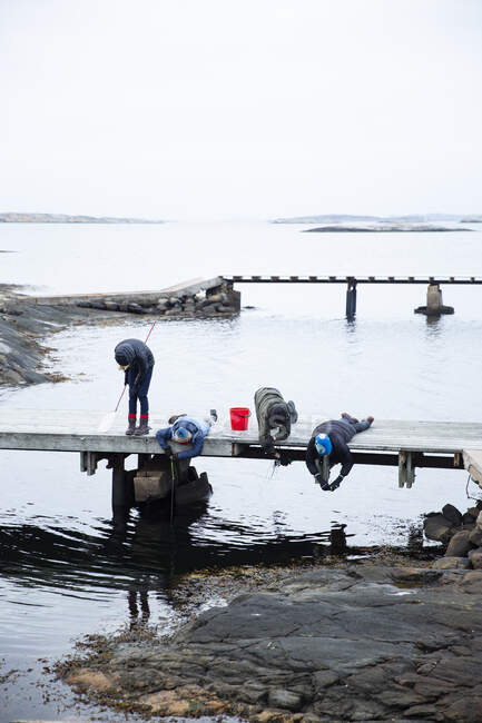 Дети рыбачат с пристани — стоковое фото