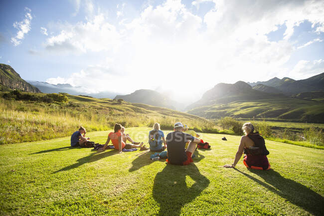 Friends sitting on Drakensberg mountain at sunset — Stock Photo