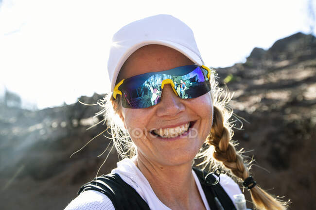 Retrato de una joven sonriente con gafas de sol - foto de stock