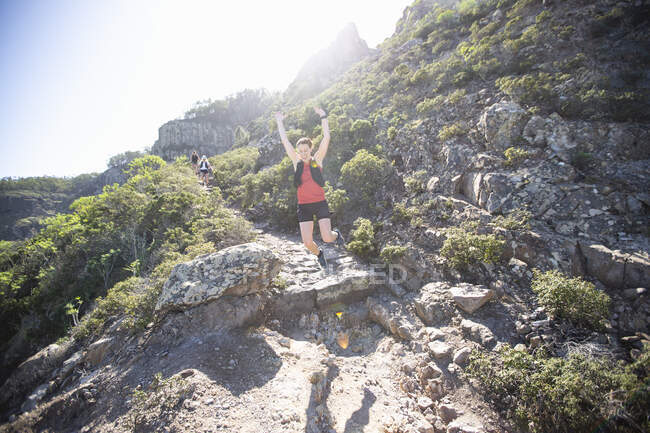 Щаслива жінка стрибає під час походу — стокове фото