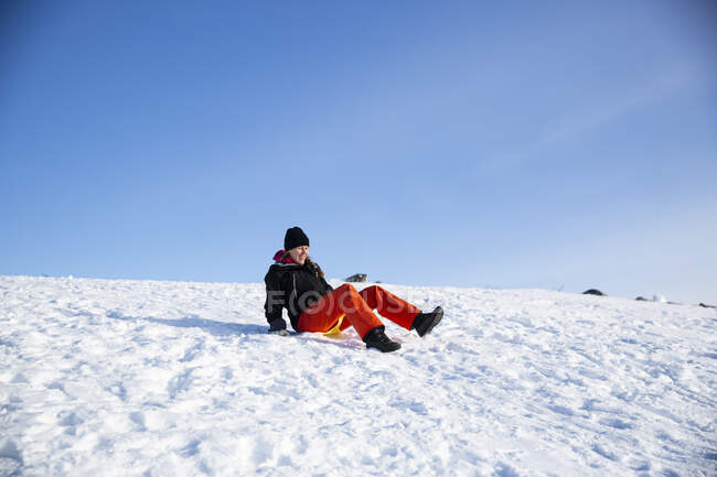 Женщина катается на санках в снегу — стоковое фото