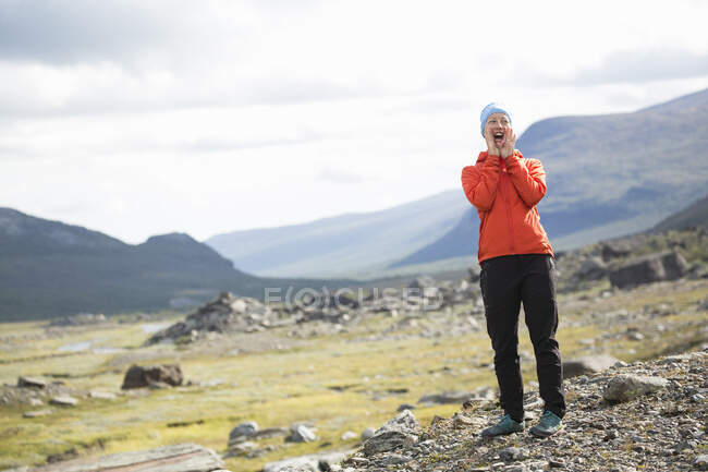 Donna in piedi vicino alle montagne durante le escursioni — Foto stock