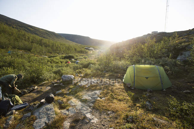 Mulher acampar ao pôr do sol — Fotografia de Stock
