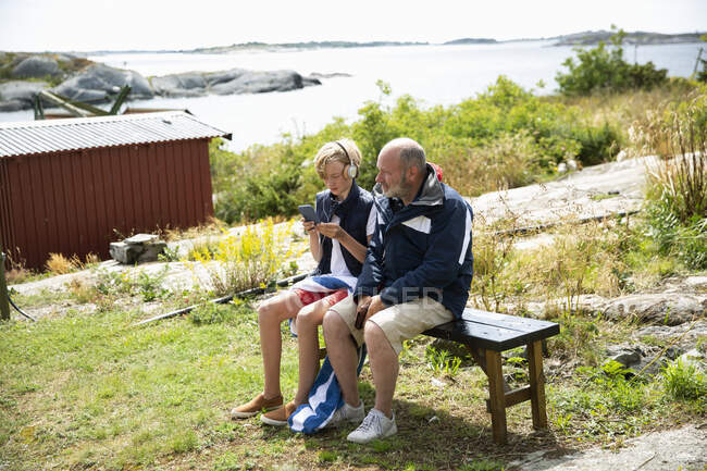 Батько і син сидять на лавці — стокове фото