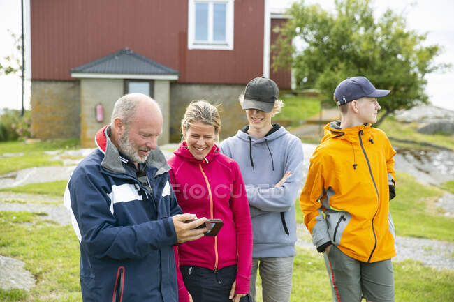 Family using smart phone — Stockfoto