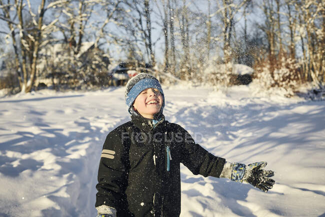 Хлопчик посміхається в снігу — стокове фото