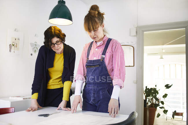 Artists looking at paper on table — Stockfoto