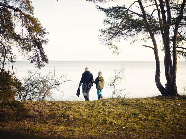 Mutter und Tochter Händchen haltend auf See — Stockfoto