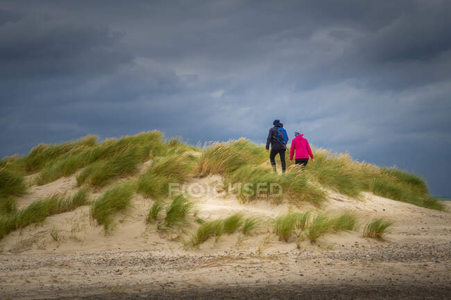 Casal andando sobre dunas de areia — Fotografia de Stock