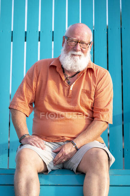 Portrait of mature man with beard sitting on bench — Stock Photo