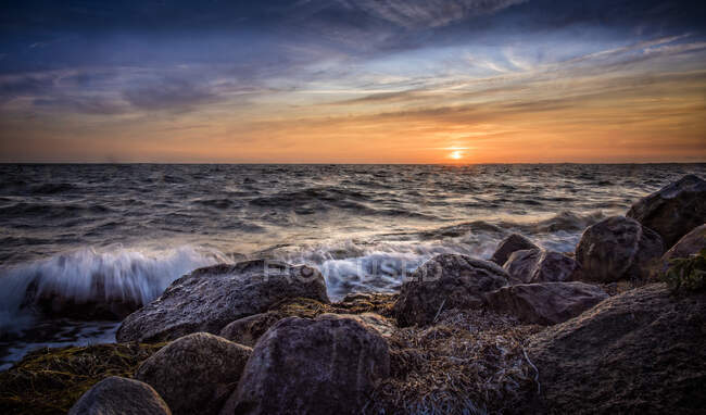 Rochers par la mer au coucher du soleil — Photo de stock
