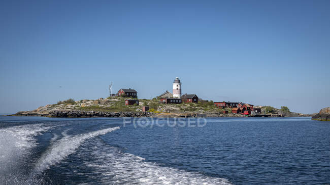 Village and lighthouse by sea — Stock Photo