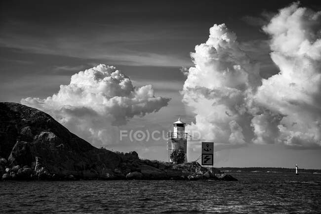 Lighthouse at coast under clouds — Stock Photo