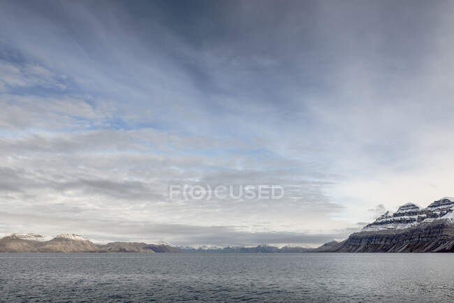Montañas nevadas y mar en Svalbard, Noruega - foto de stock
