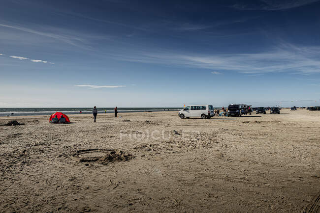 Personas y coches en la playa - foto de stock