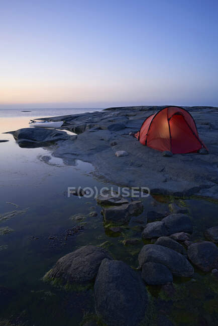 Палатка на скалах по морю — стоковое фото