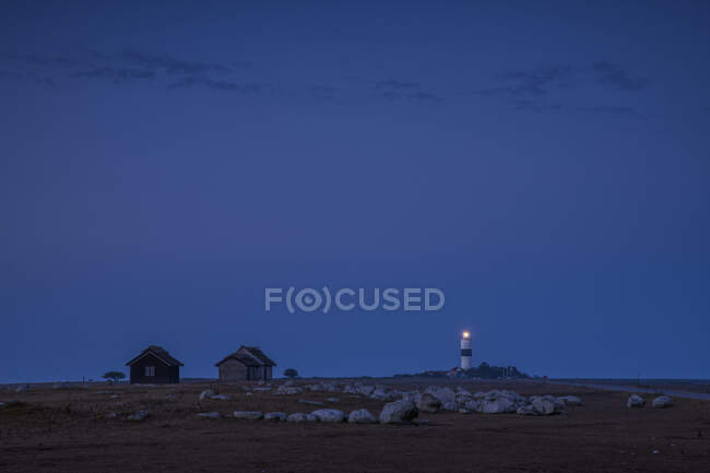 Leuchtturm und Hütten bei Nacht — Stockfoto