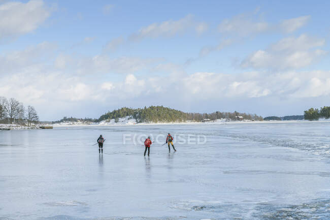 Persone pattinaggio su ghiaccio sul lago ghiacciato — Foto stock