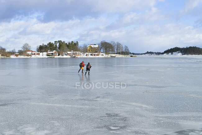 Persone pattinaggio su ghiaccio sul lago ghiacciato — Foto stock