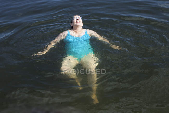 Reife Frau schwimmt im See — Stockfoto