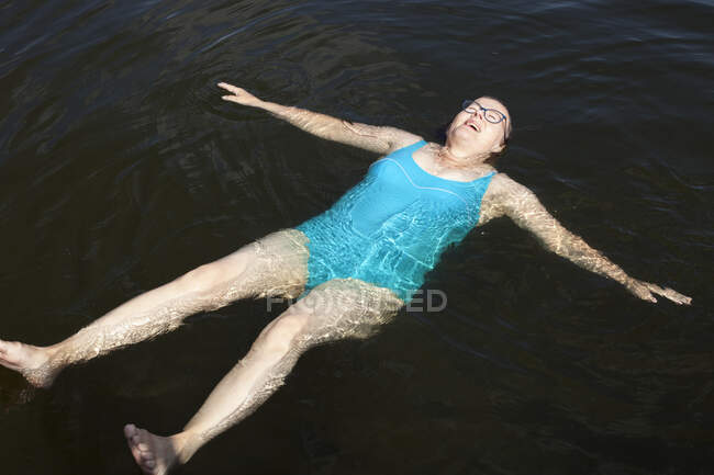 Femme mûre nageant dans le lac — Photo de stock