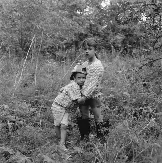Hermanos abrazándose en el bosque - foto de stock