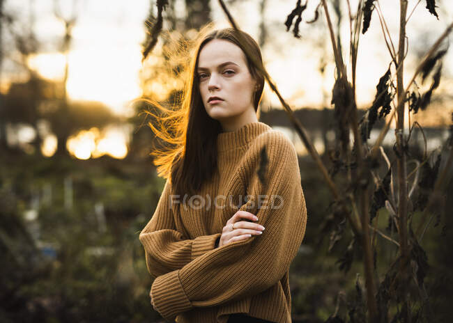 Молода жінка на заході сонця в полі — стокове фото