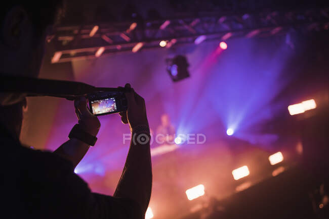 Uomo scattare foto con smartphone in concerto — Foto stock