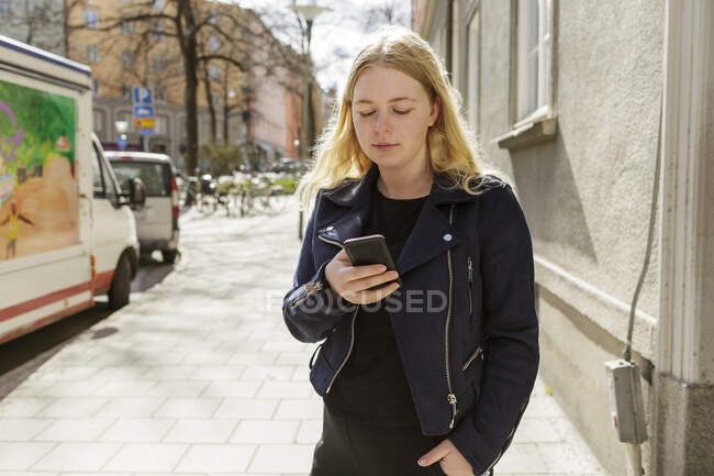 Jeune femme utilisant un téléphone intelligent à Stockholm, Suède — Photo de stock