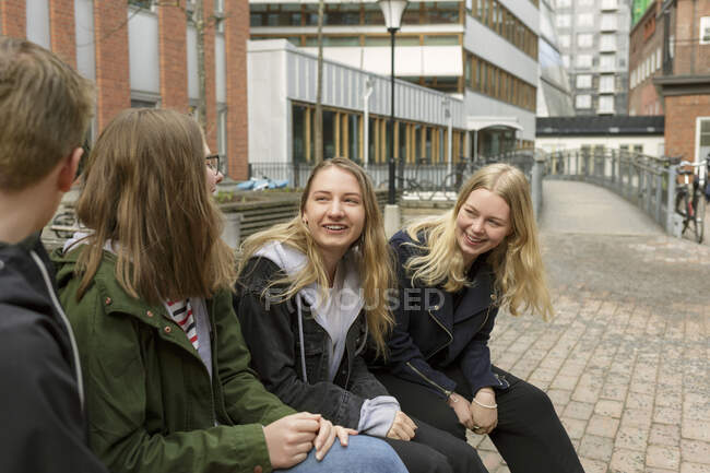 Amigos sentados en el banco en Estocolmo, Suecia - foto de stock