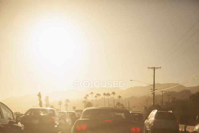 Автомобілі, що їздять по дорозі на заході сонця — стокове фото