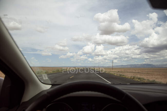 Вітрове скло автомобіля, що їде по пустельній трасі — стокове фото
