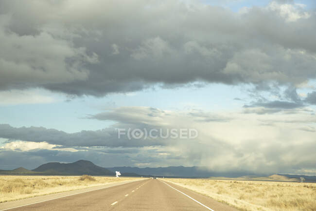 Autopista a las colinas bajo las nubes - foto de stock