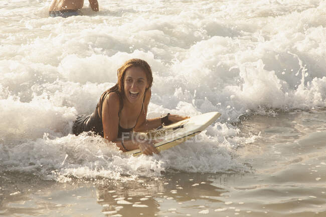 Frau mit Board im Meer — Stockfoto