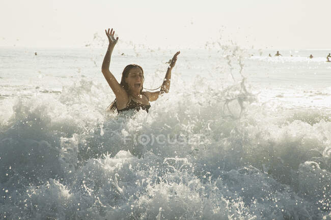 Femme jouissant de vagues à la plage — Photo de stock