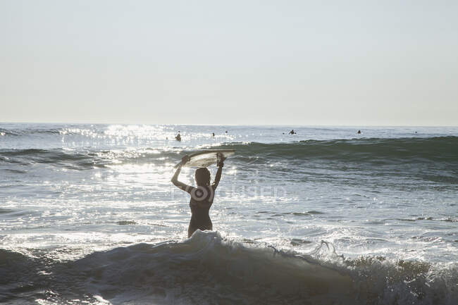 Frau mit Board im Meer — Stockfoto