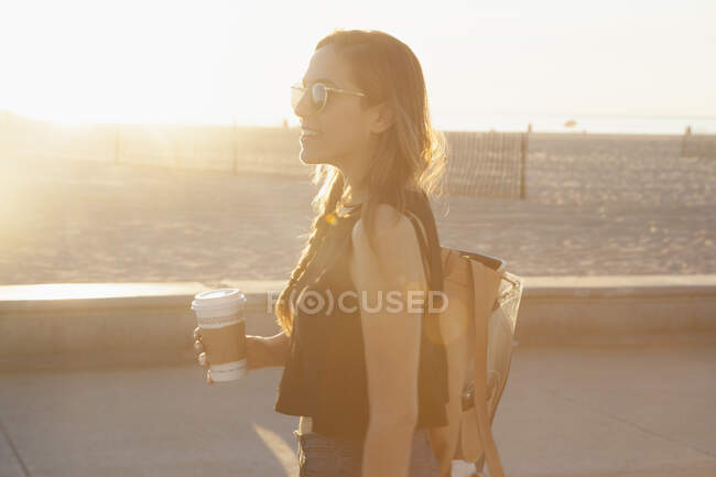 Jovem mulher durante o pôr do sol em Venice Beach, Califórnia — Fotografia de Stock