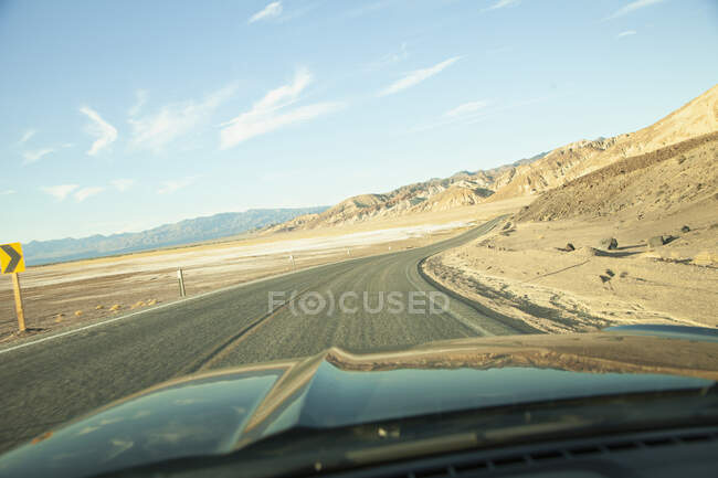 Hood of car driving on dessert highway — Stock Photo
