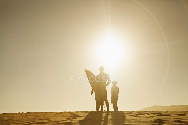 Люди, що стоять на піщаній дюні під час заходу сонця — стокове фото