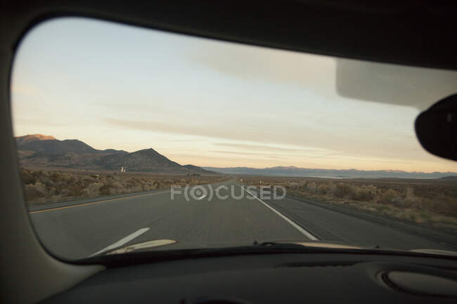 Windscreen of car driving on desert highway — Stock Photo