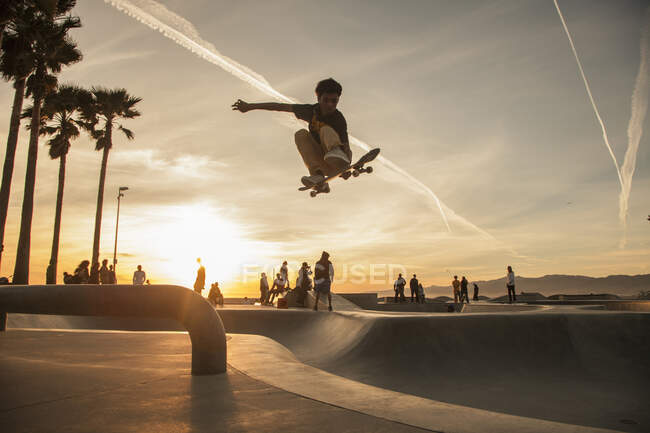 Teenage boy skating at skatepark during sunset — Stock Photo