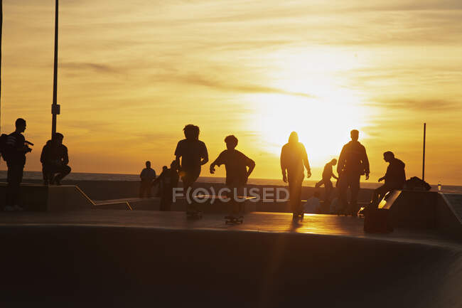 Підлітковий хлопчик катається на скейтпарку під час заходу сонця — стокове фото