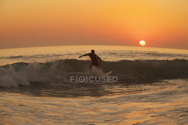 Homme surfant sur la plage de Laguna au coucher du soleil — Photo de stock