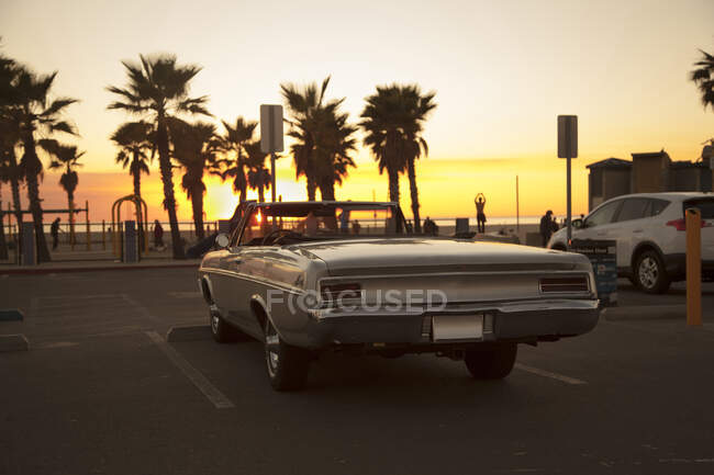Coche de época en el aparcamiento durante la puesta del sol en Venice Beach - foto de stock