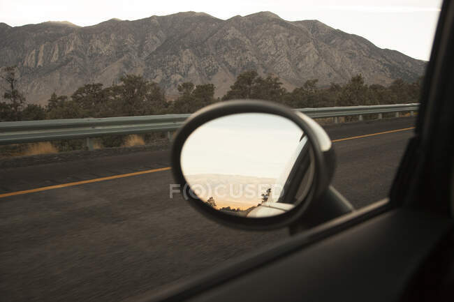 Außenspiegel von Auto fährt auf Autobahn — Stockfoto