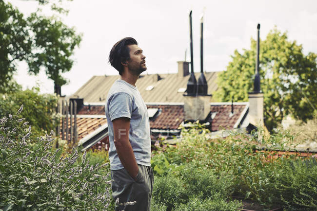 Homem de pé no jardim por casa — Fotografia de Stock